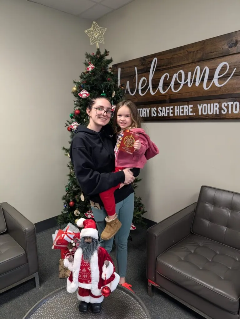 Parent and daughter receiving holiday support inside Augusta office