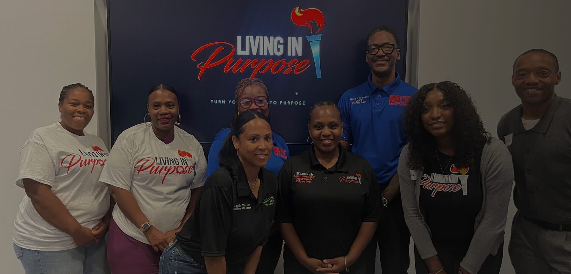 Living in Purpose team members standing together in front of organization signage