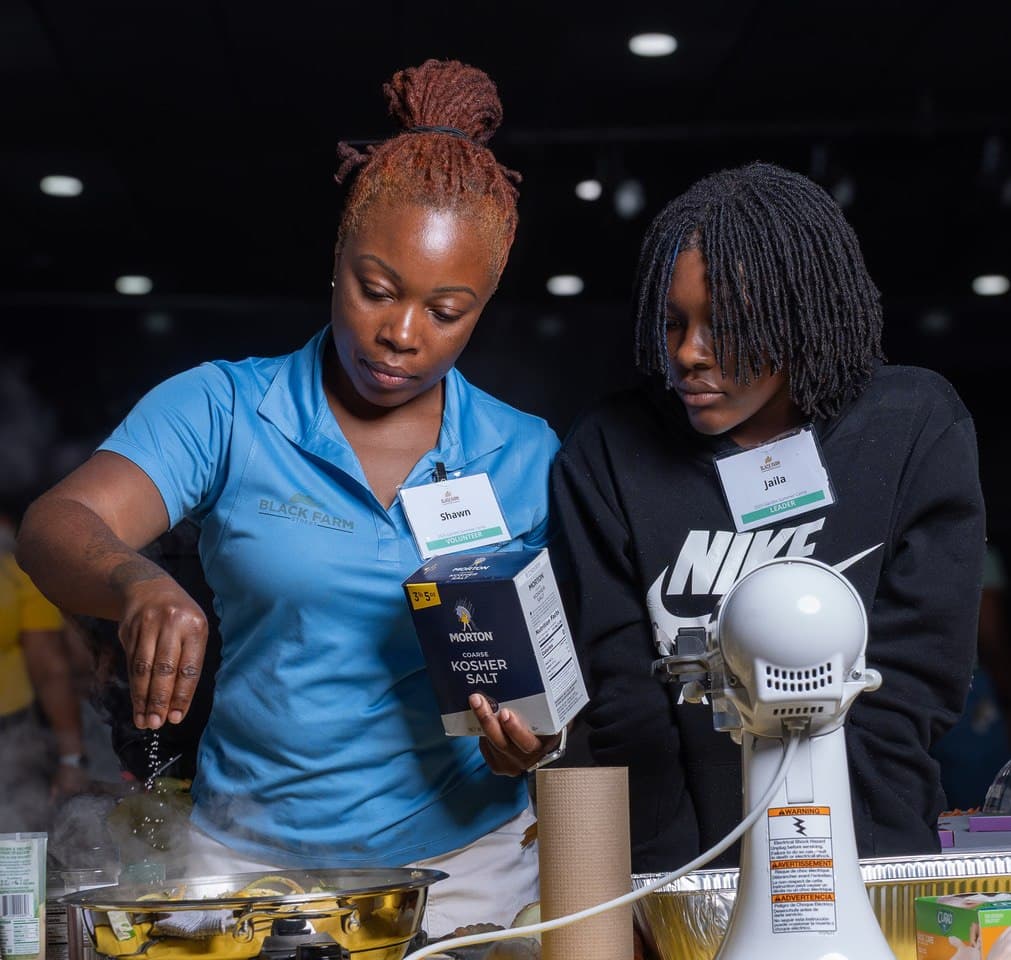 A Living in Purpose staff member and a student preparing food together in a cooking class